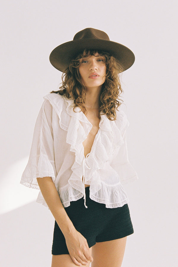 Model wearing an Espresso Rancher wool felt hat in brown, styled with a white ruffled top and black shorts.