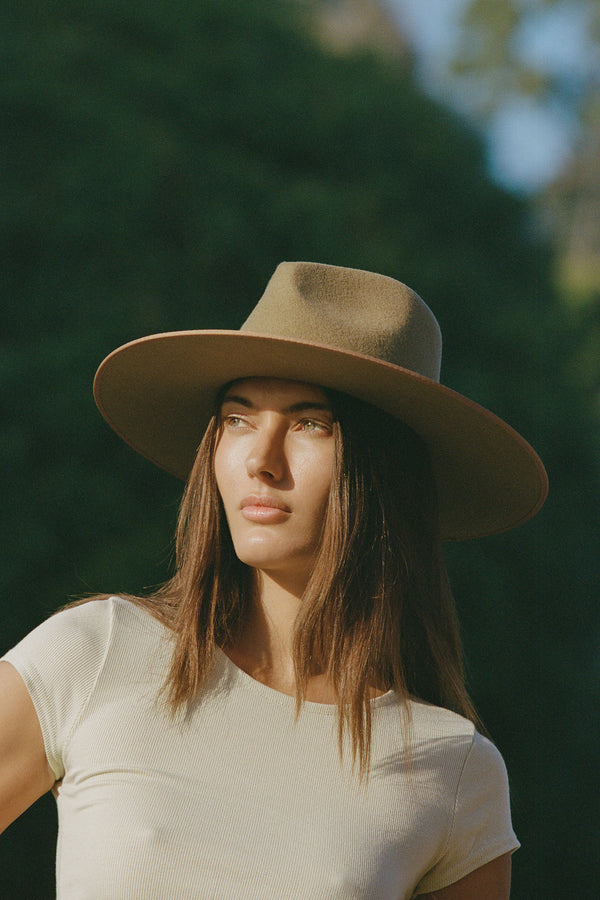 Model wearing the Teak Rancher wool felt fedora hat in brown, showcasing its design and style.