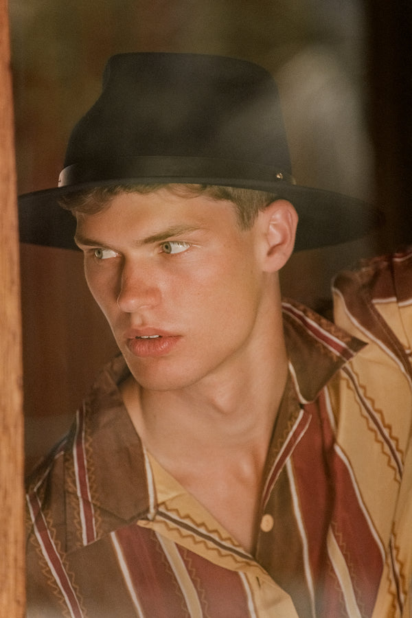 Model wearing the Diego black wool felt fedora hat, featuring a stylish look.